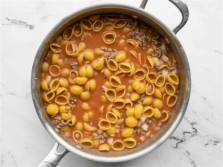 Image of Add the uncooked pasta to the skillet and stir to...