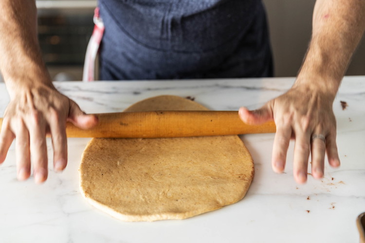 Image of Flatten one ball into a rectangular shape. With a rolling pin, roll it into a 9 × 12-inch rectangle.