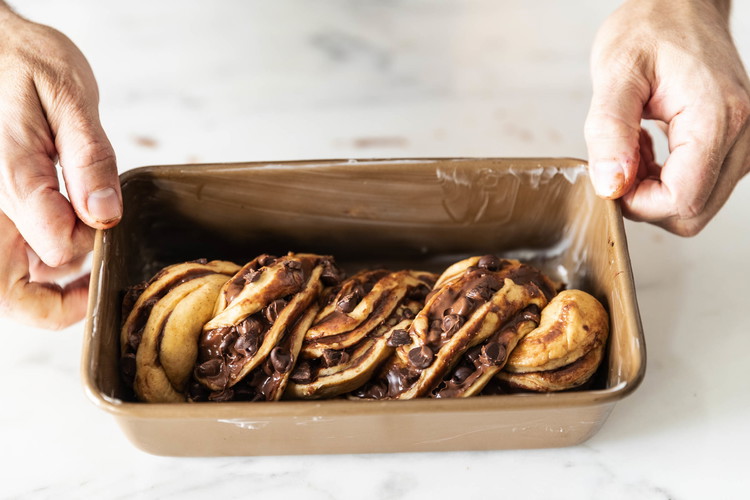 Image of Transfer the twist to one of the prepared pans. Repeat with the remaining dough. Cover both pans with a clean kitchen towel and let rise in a warm place until the dough has risen to the pans’ rims, about 45...