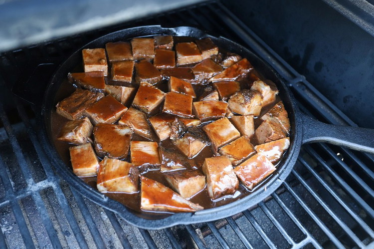 Image of Place skillet on the grill grate, over indirect heat.  Cook for 2 to 3 hours, rotating pieces halfway through cooking.