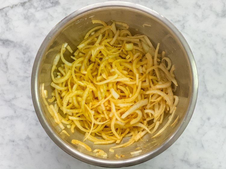 Image of In a large mixing bowl, combine your sliced onions, salt,...