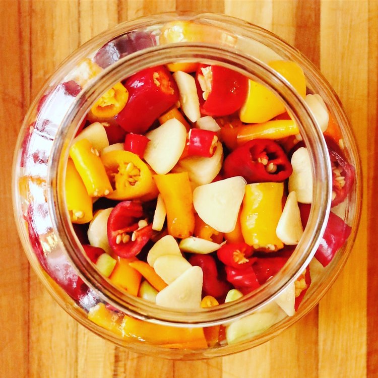 Image of Pack peppers, onion
and garlic into fermentation jar.