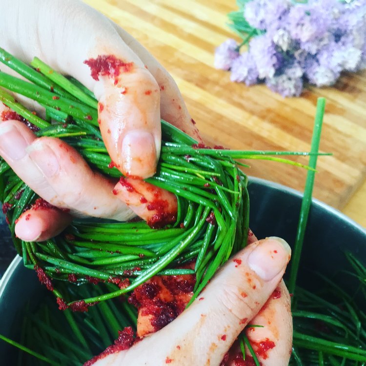 Image of Working in handfuls, add kimchi paste to chives and using...