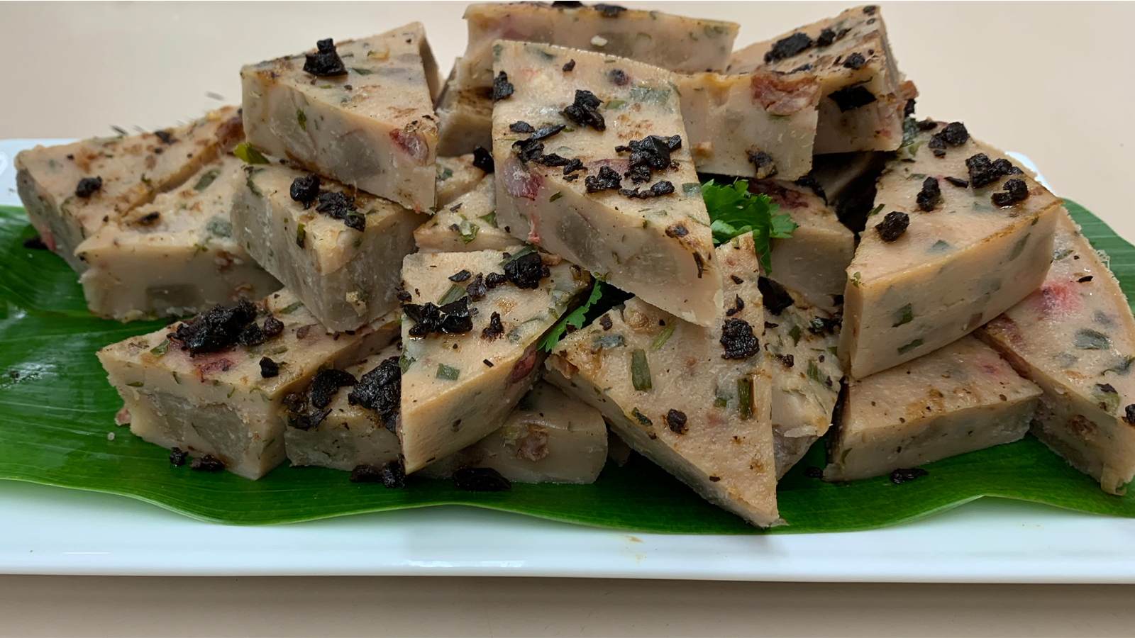 Kalo (taro) dim sum dish cut into triangles on a plate