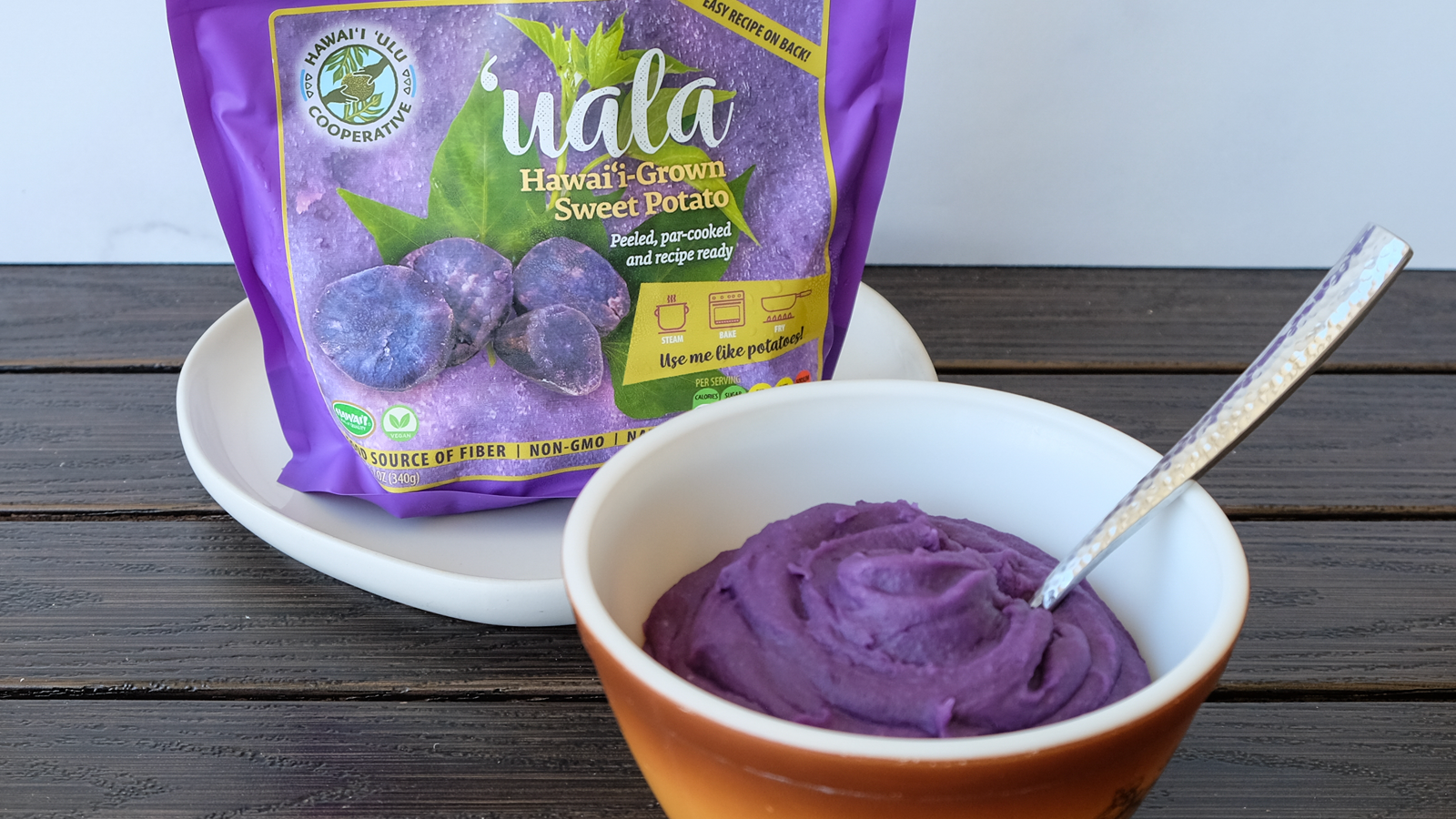 Bag of recipe-ready Okinawan sweet potatoes next to a bowl of mashed ʻuala.