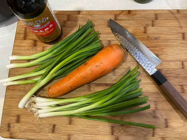Image of To make the broth, combine the scallions, carrots, garlic, ginger,...