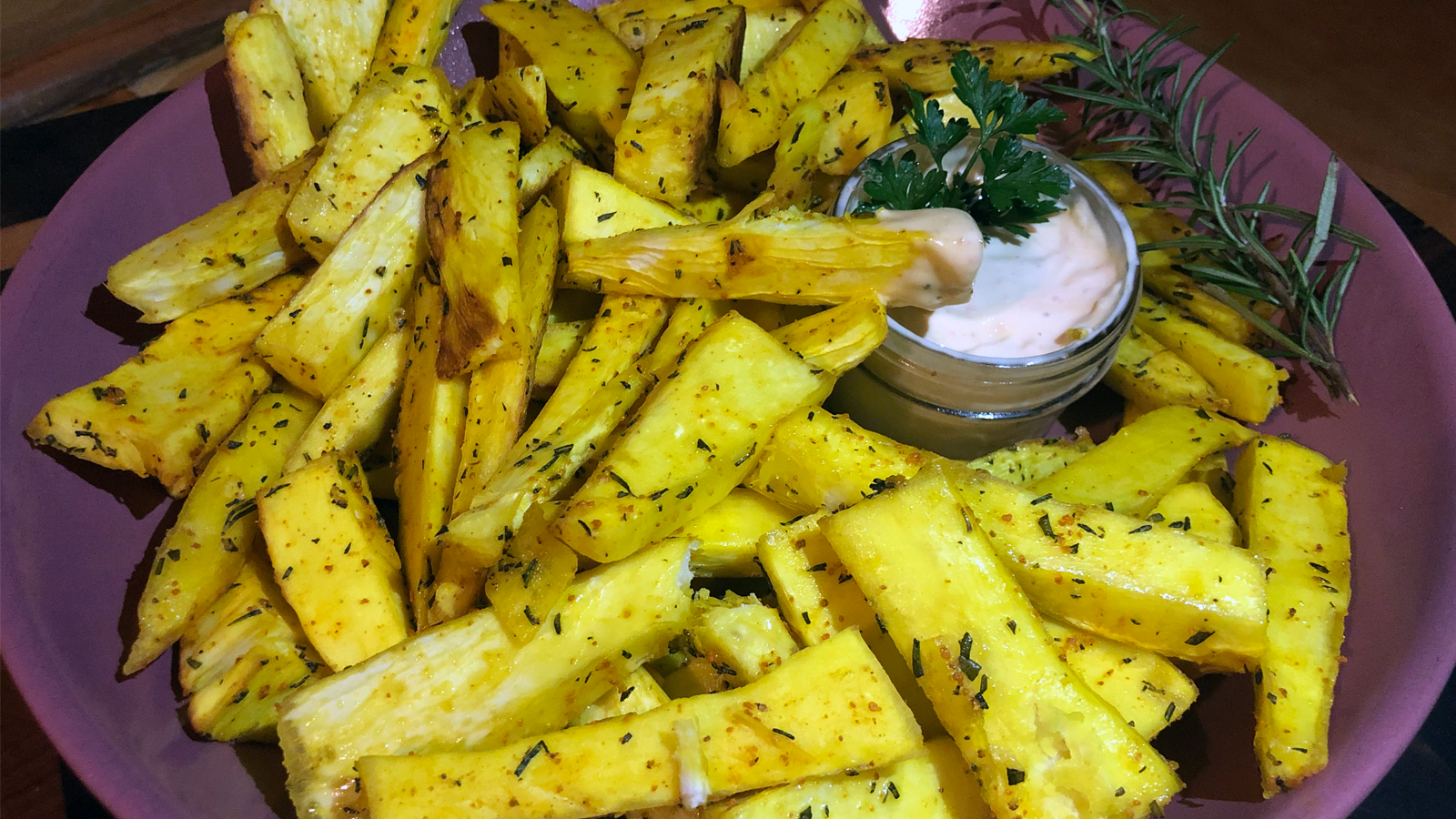 Brightly colored cassava fries plated with aioli