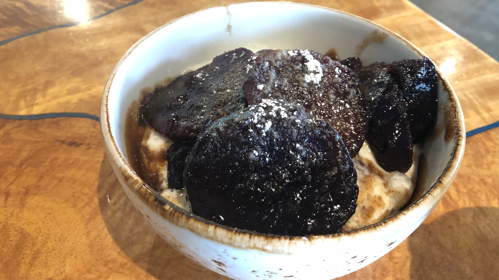 ʻUala slices drizzled with a sweet glaze over vanilla ice crea.