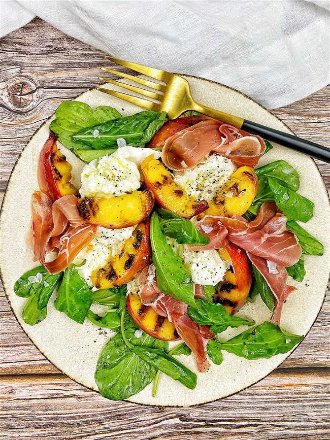 Image of Ensalada de mozzarella, jamón serrano y duraznos grillados