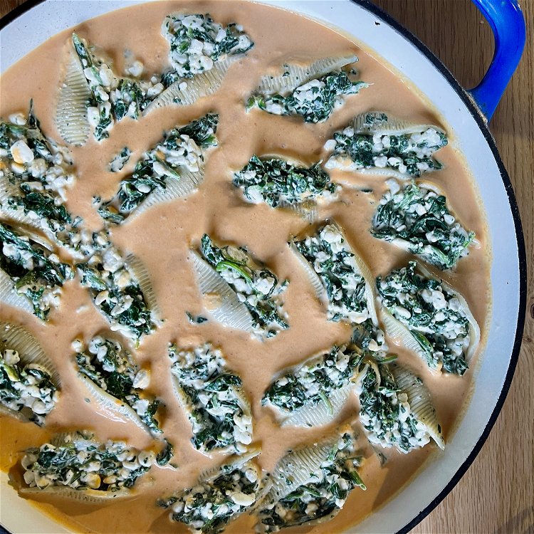 Image of Arrange the stuffed shells evenly into the pan of sauce.