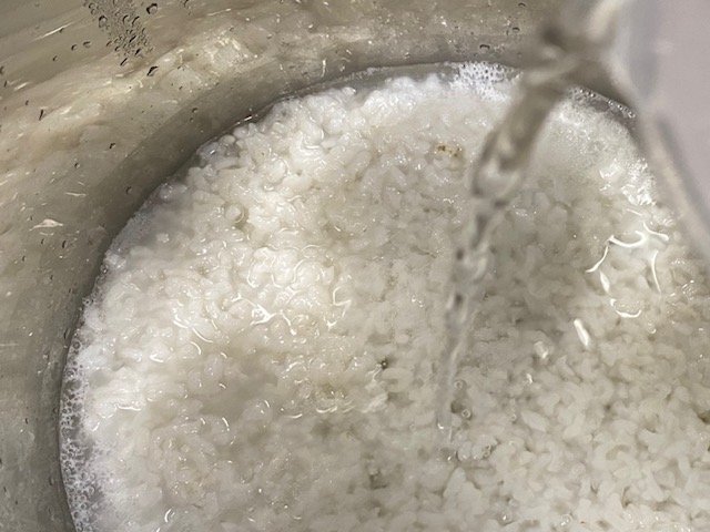 Image of Adding water (270ml) to the cooked rice.