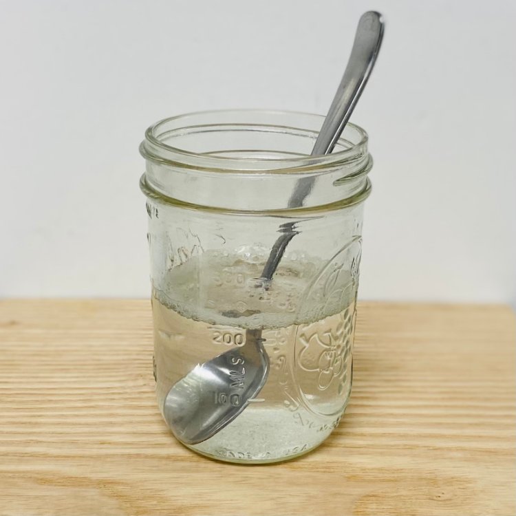 Image of Pour the water in the container. Then using a spoon,...
