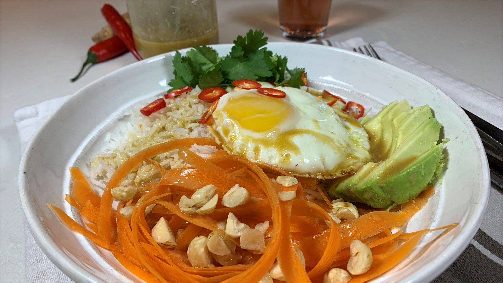 Image de bol de riz basmati avec œuf au plat, avocat, carottes et vinaigrette au soja