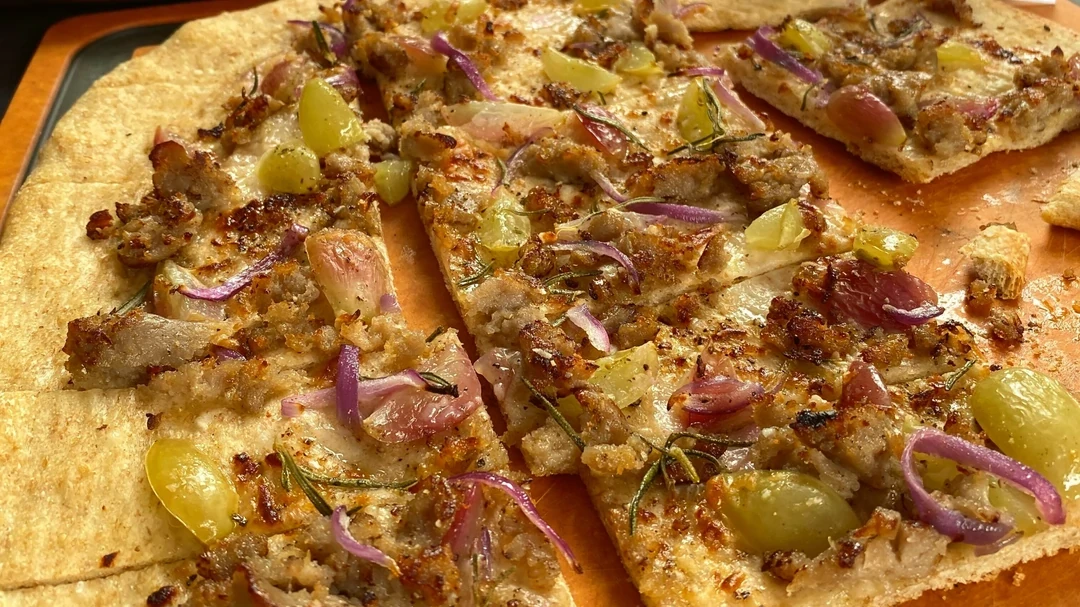 Image de pizza au poulet à base de plantes avec raisins, romarin et miel