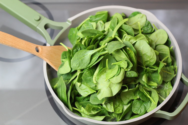 Image of Add spinach, a large pile at a time until it all fits in the pan