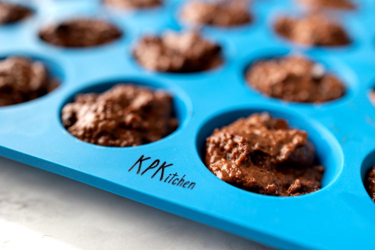 Image of Divide the batter evenly into each muffin cup, filling all...