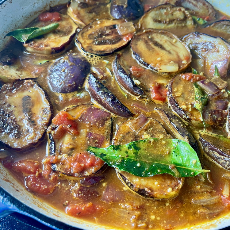 Image of Place the eggplant back into the pan and add 2 cups of water, enough to just cover the eggplant and fold the ingredients well to combine.