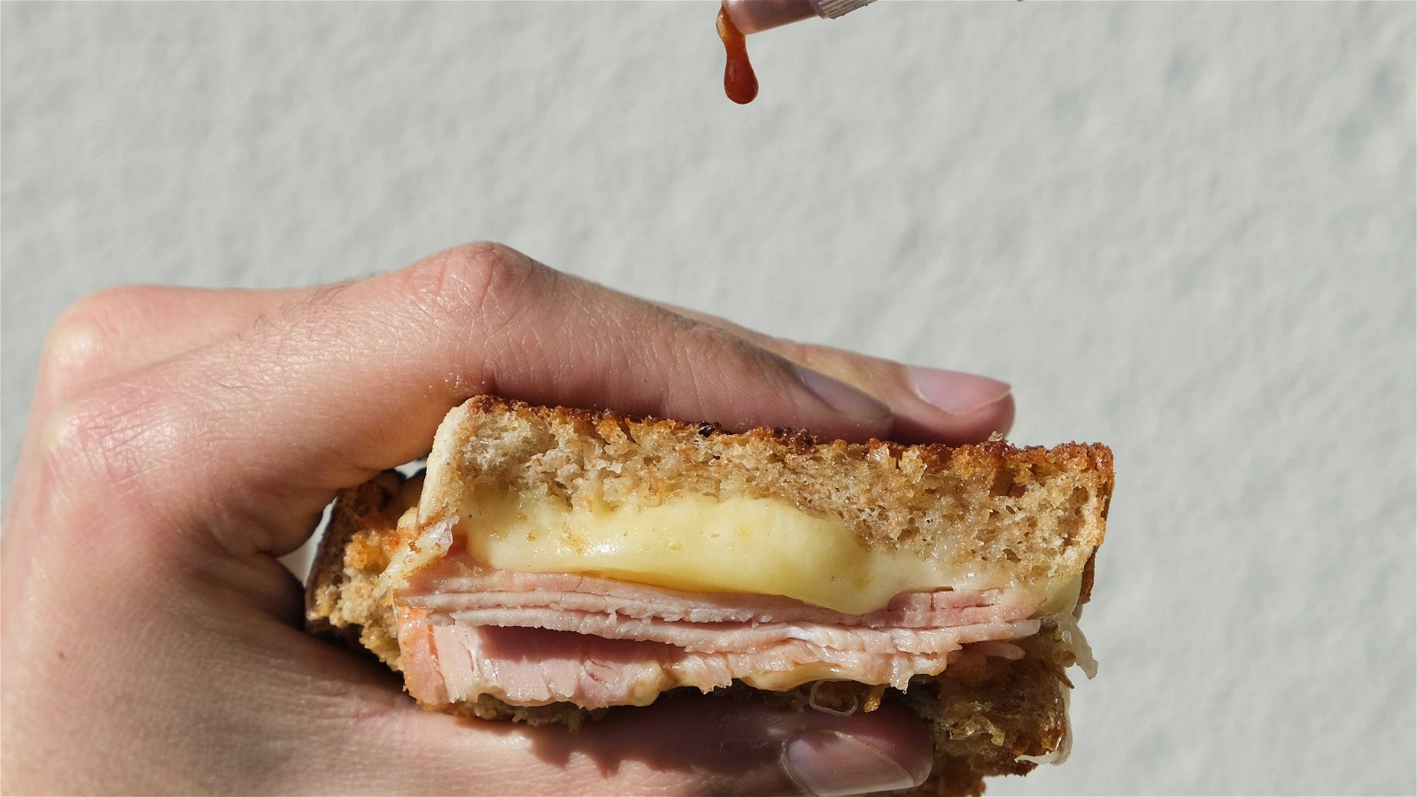 Image of Toastie fromage, jambon fumé, crème d'ail et sauce piquante