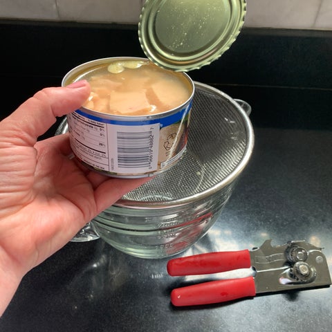 Image of Drain and flake canned chicken using a fork. Remove as much liquid as possible.