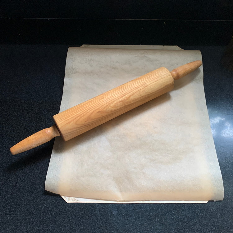 Image of Cover with a piece of parchment paper and gently roll into a thin crust.
