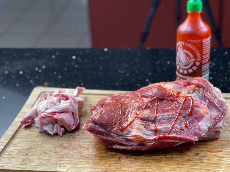 Image of Now that the lamb shoulder is trimmed up, it is time to apply your hot sauce and this is where you are allowed to rub and not pat 😏Ensure the shoulder is coated as this will assist your seasoning in...