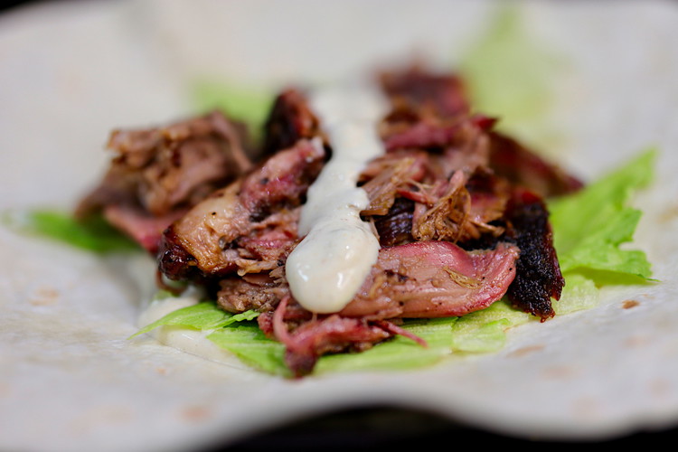 Image of Start with your wrap or pita bread and layer your favorite salad, but in this case I used iceberg lettuce as it retains some textural crunch. Then a heavy lashing of the sauce, a metric crapload of lamb, then you...