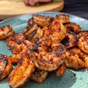 Image of Place shrimp on the cook top, cook 2-3 minutes on each side. The shrimp should reach an internal temp of 120 degrees before removing them from the grill.