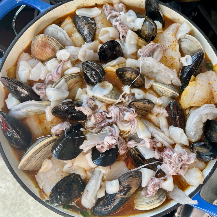 Image of Arrange the mussels, shrimp, and squid in the pan and continue cooking for 5 more minutes, covered, or until the rest of the seafood is cooked.