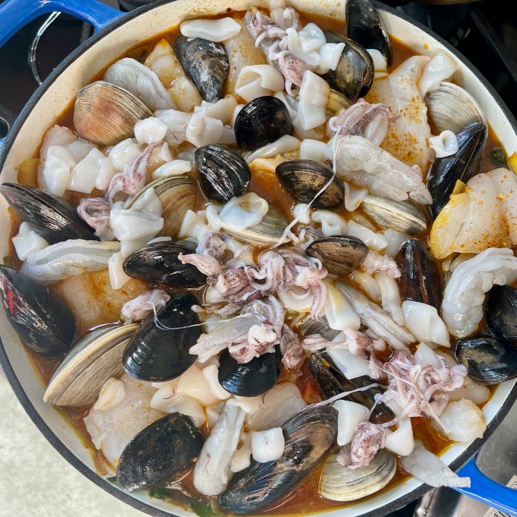 Image of Arrange the mussels, shrimp, and squid in the pan and...