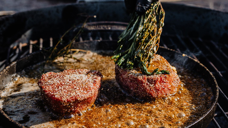 Image of As the steak cooks, use the whole bunch of fresh thyme to mop melted butter over the filets as they cook. Not only does this method baste your steak with butter to keep it moist as it cooks, but it...