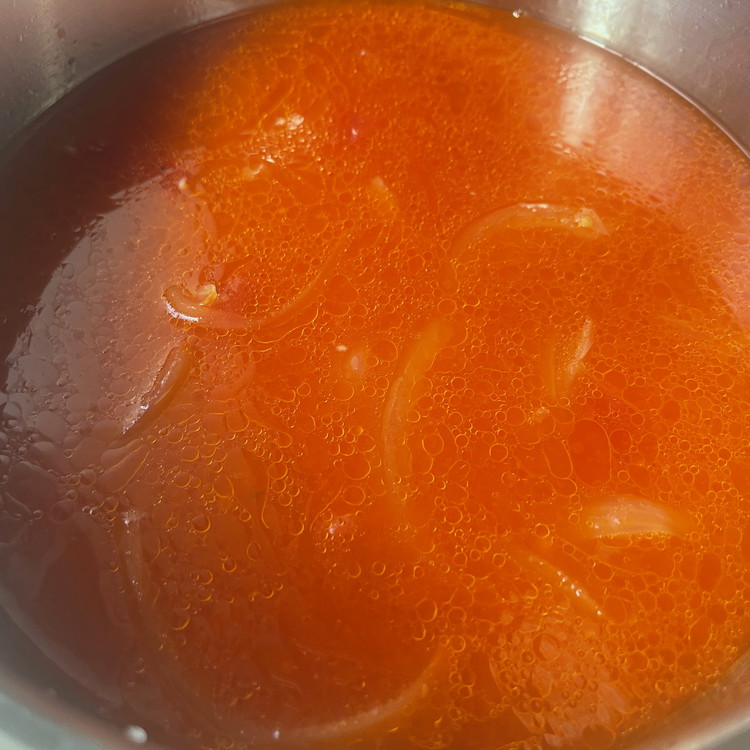 Image of Add the tomato dice and use the empty can to measure and add a full can of water.