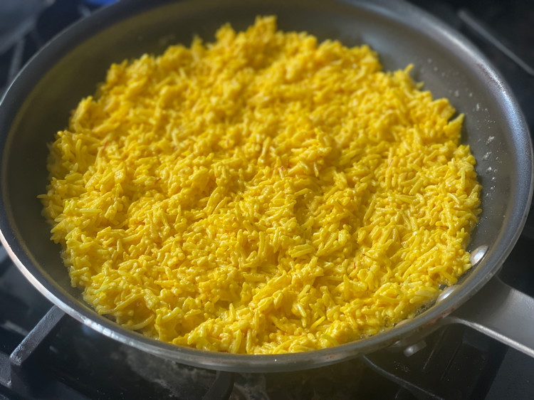 Image of Layer the saffron rice mixture evenly into the bottom of the pan.