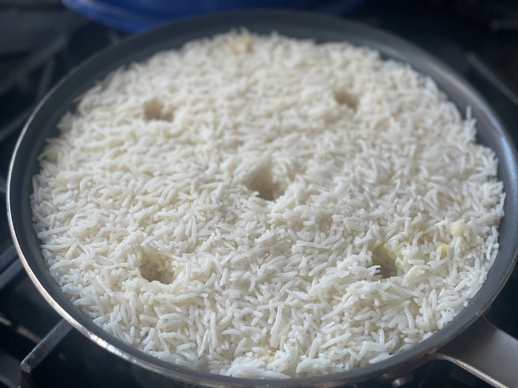 Image of Add the remaining seasoned rice on top.  Smooth the layer over evenly but gently to avoid packing the rice.  The result will be fluffy and crisp instead of dense and tough. 