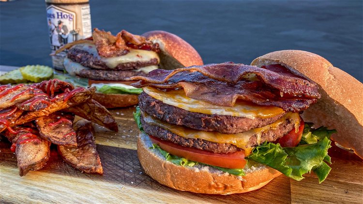 Image of Place bacon over each burger patty and stack two burgers...