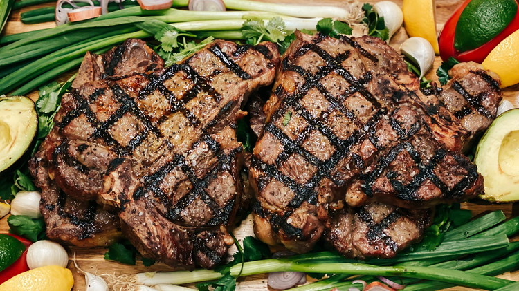 Image of Re-season steak when pulled from grill and let rest. Top with a compound butter and garnish.