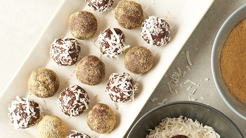 Platter of chocolate energy balls with coconut flakes