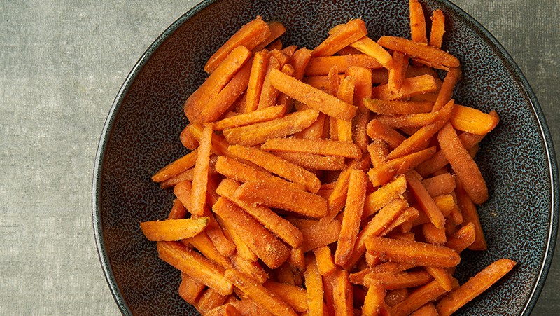 Plate of roasted carrots with date sugar seasoning.