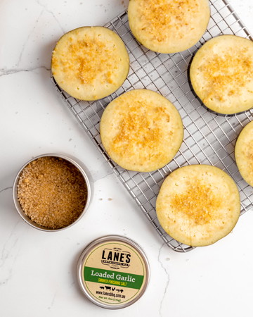 Image of Sweat eggplants by coating in finishing salt (both sides), leave on a wire rack for at least 30 minutes. Proceed to pat dry.