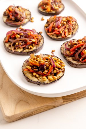Image of Top cooked eggplant with capsicum, onion, and pine nuts.