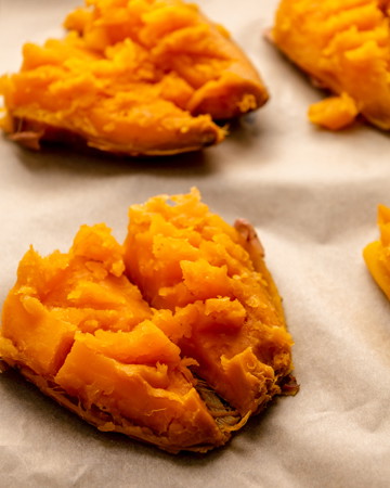 Image of Once boiled, lay potato skin side down on baking tray. Using a potato masher, gently mash the top of the potato. Drizzle with oil and bake for 20 minutes or until roasted.