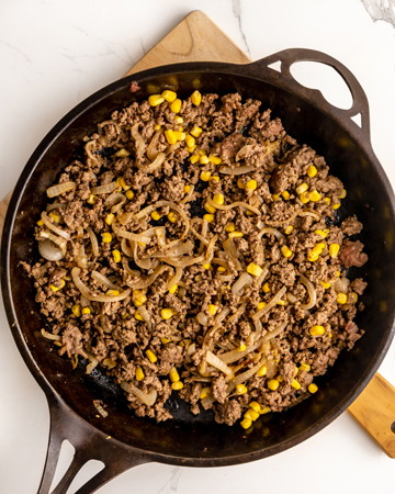 Image of Add onion and garlic to frying pan and cook until softened, approximately 1 minute. Add beef mince and cook for 5-7 minutes or until browned. Stir through corn and cook until heated through.