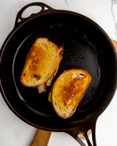 Image of 6. Place the sandwich butter side down on the pan or on a sandwich press. Cook on low until golden and cheese has melted.