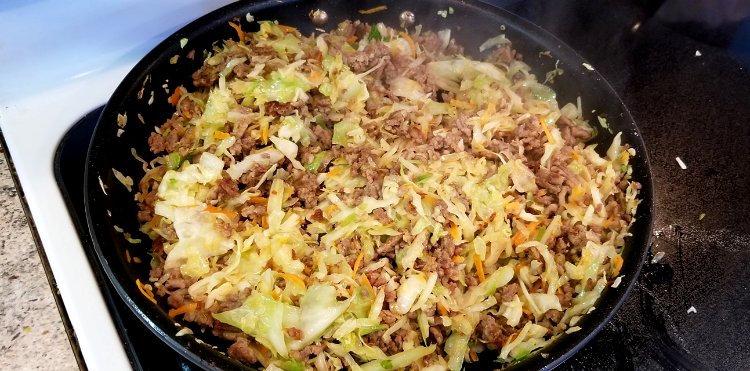 Image of Add in garlic, cabbage/coleslaw mix, onion and egg