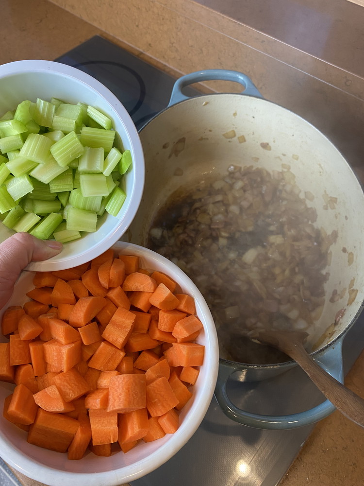 Image of Once the bacon is cooked down add the carrots and celery and cook for five minutes.