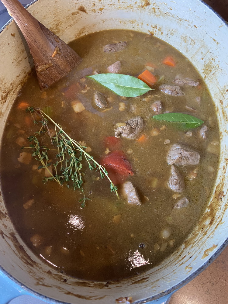 Image of Add the beef back to the pan along with your beef stock, tomato paste, thyme, and Bay leaves