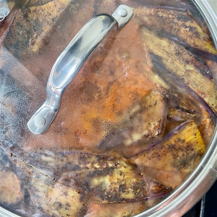 Image of Arrange the browned eggplant back on top, cover, and simmer...