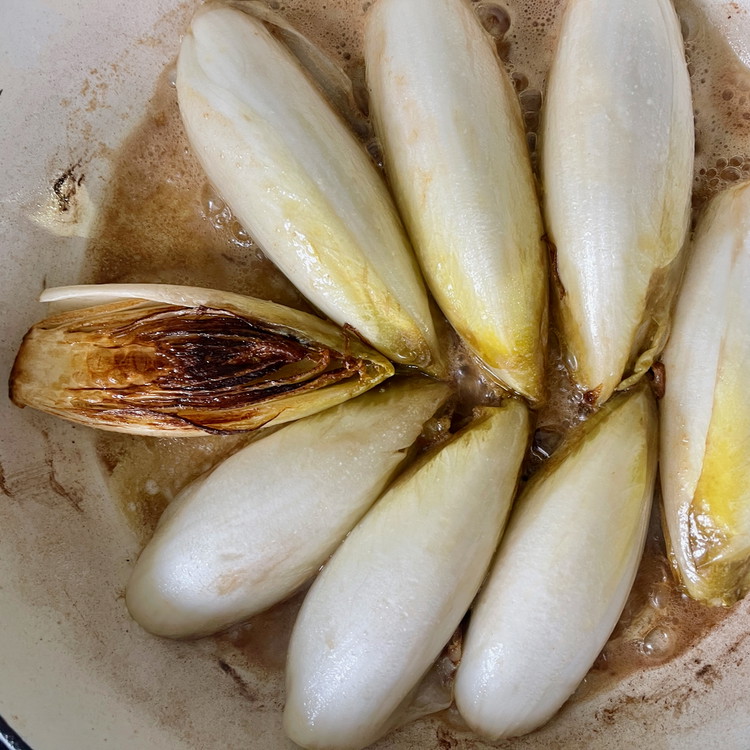 Image of Add the butter and continue caramelizing until the cut face of the endive is nicely browned.