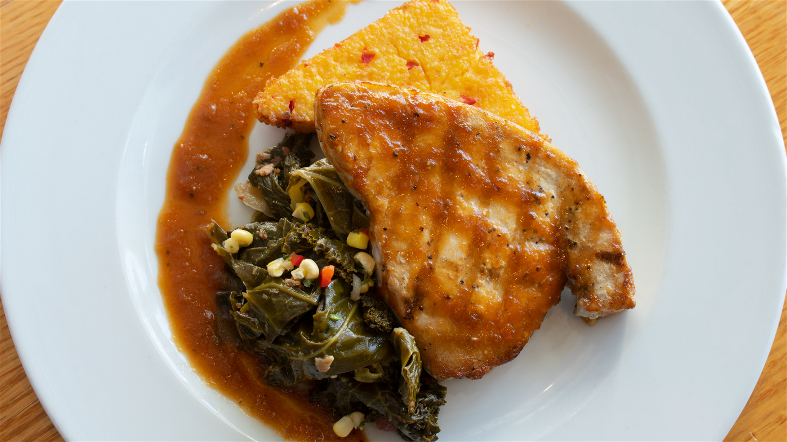 Image of Grilled Mahi with Collards & Grit Cake finished with Ginger Dressing 