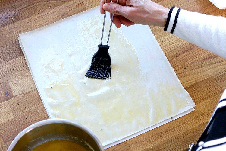 Image of Eine feine Scheibe vom Filoteig gründlich mit etwas geschmolzenen Butter...