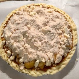 Image of Spoon the apple filling and juice into the pie crust,...